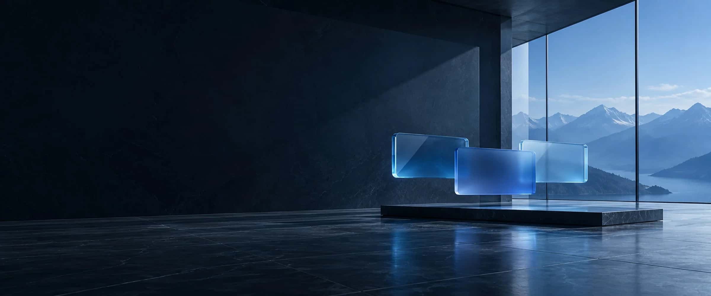 Three blank blue glass panels suspended above a dark reflective floor, with mountains beyond a studio window.